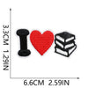 Three embroidered iron-on patches shaped like the letter I, a heart, and a stack of books.