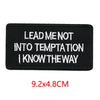 Black iron-on embroidered letter patch with white text that reads Lead me not into temptation I know the way