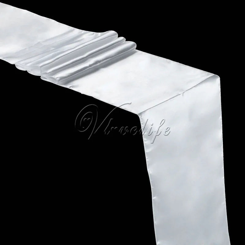 A white satin table runner draped elegantly, showing soft folds and luxurious texture.