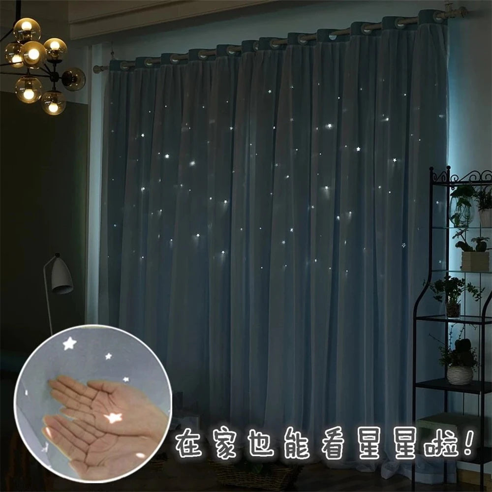Gray blackout curtains featuring a star pattern and sheer lace overlay hanging in a window.