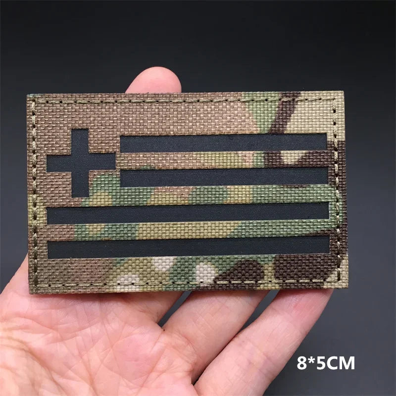 A close-up of a tactical patch featuring the American flag design in camouflage fabric.