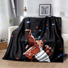 A black flannel blanket featuring a graphic print of a person performing with dynamic lighting effects.