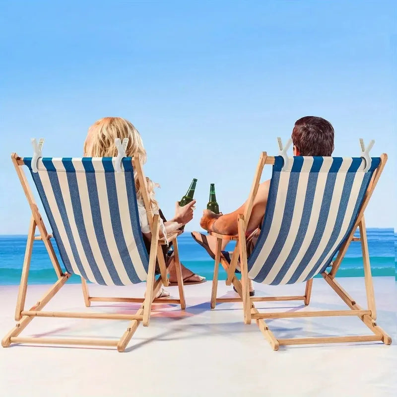 Two people relax in deck chairs on a beach with plastic clothespins visible.