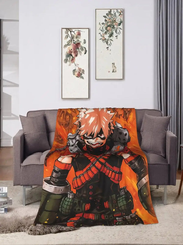 An orange and black patterned throw blanket draped over a gray sofa in a brightly lit room.