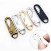 A set of five metal zipper pulls in gold and black finishes shown with a close-up of one being held by a finger