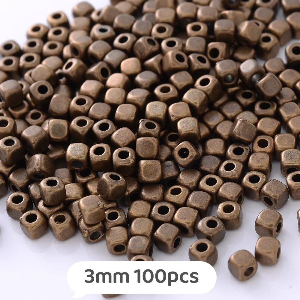 A pile of small, geometric brass or bronze beads used for jewelry making