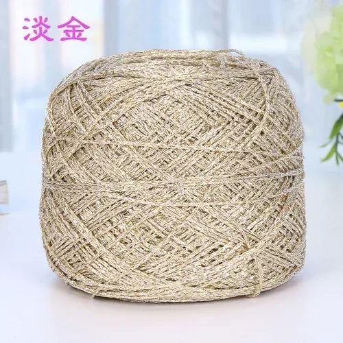 A ball of metallic silk crocheting and knitting yarn with a beige color.