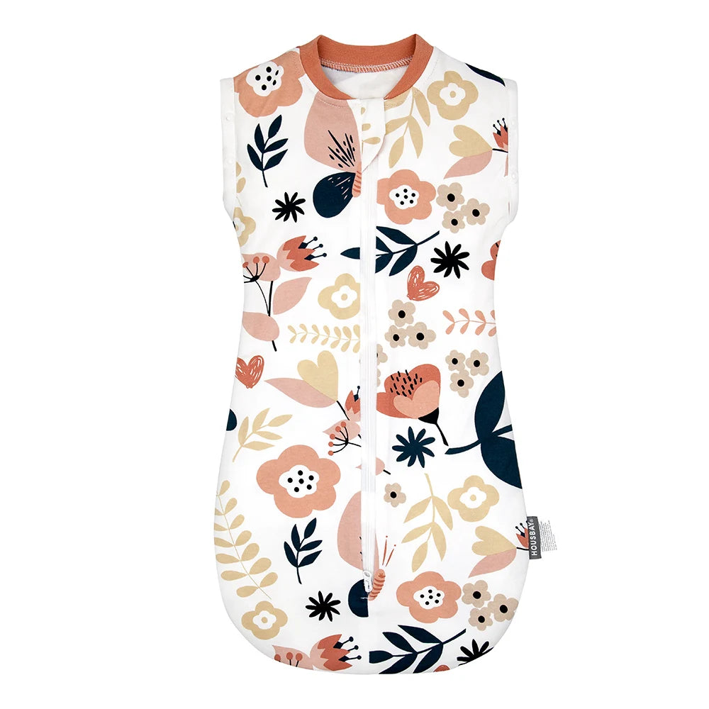 A white baby sleeping bag or swaddle featuring a floral pattern of pink, peach, and dark green leaves and flowers.