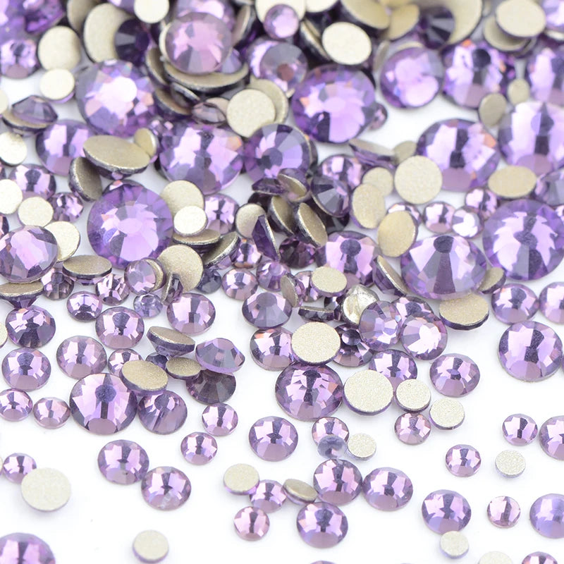 A pile of iridescent purple and gold glass rhinestones for DIY crafts