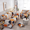 A modern living room features an orange and gray patterned sofa and armchair with sheer curtains.