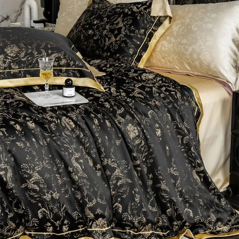 Black floral duvet cover with gold trim and beige sheets and pillows.