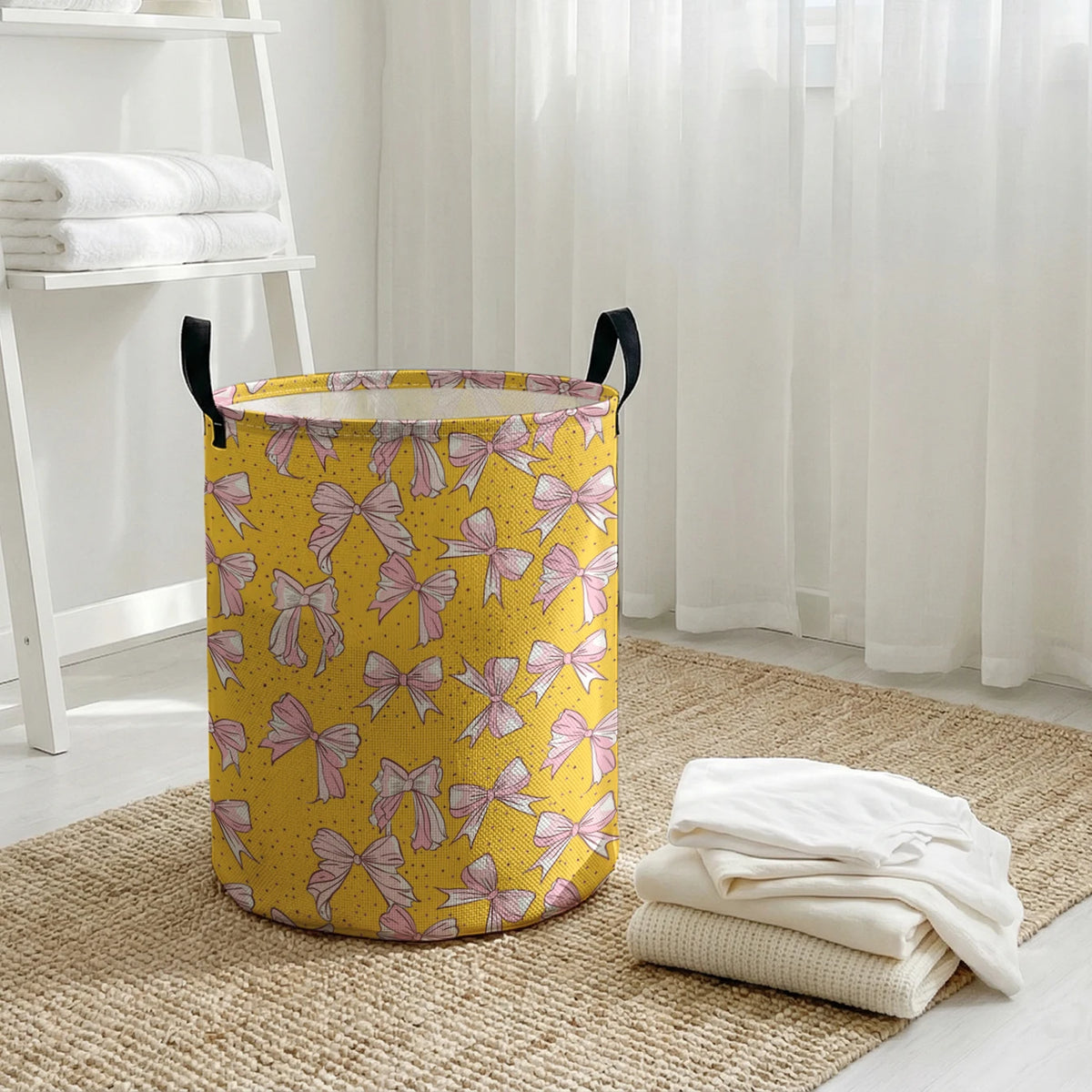 A yellow laundry basket with a pink bow pattern sits on a woven rug next to a white shelf.