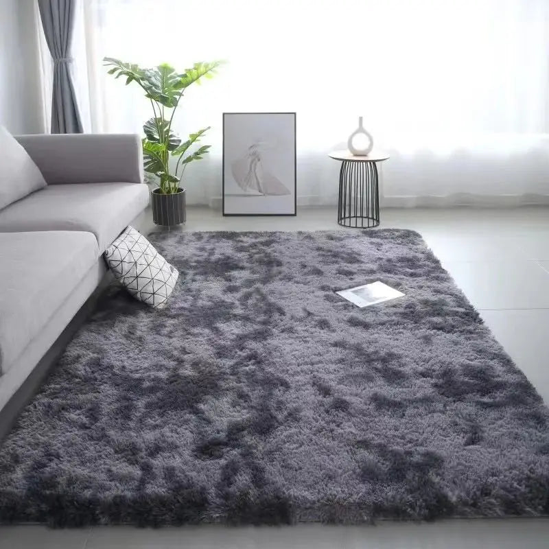 A gray fluffy rug in a living room with a window and potted plant.