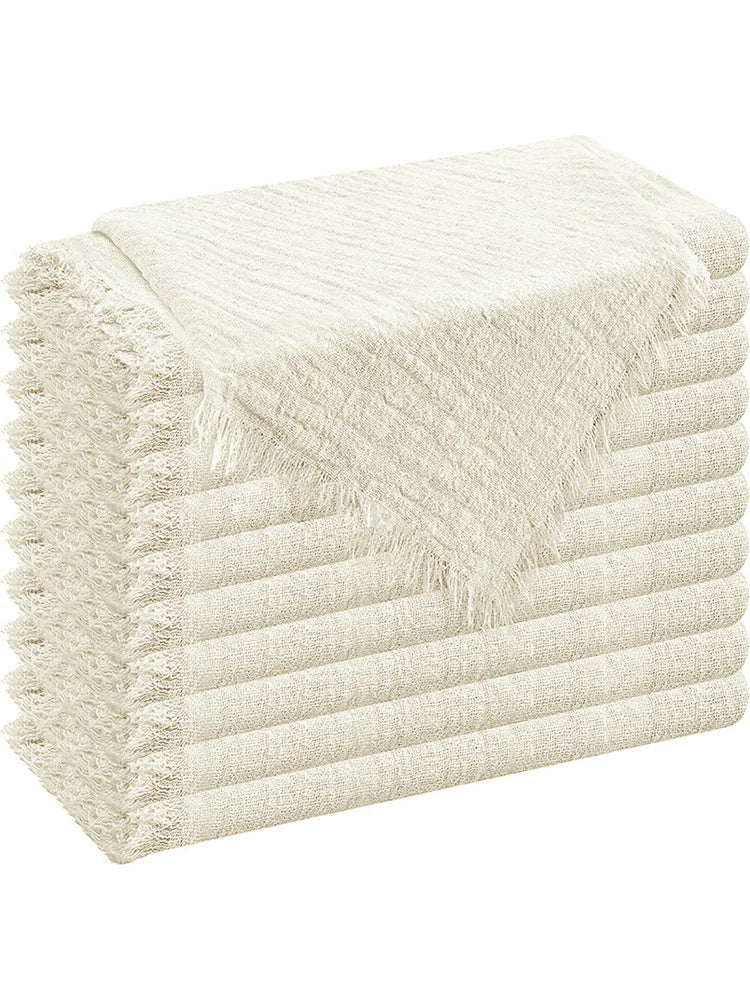 A stack of cream-colored decorative cloth napkins folded neatly.