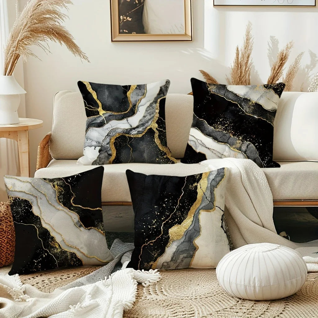 Black and gold marble print decorative pillow covers on a beige sofa with natural light.