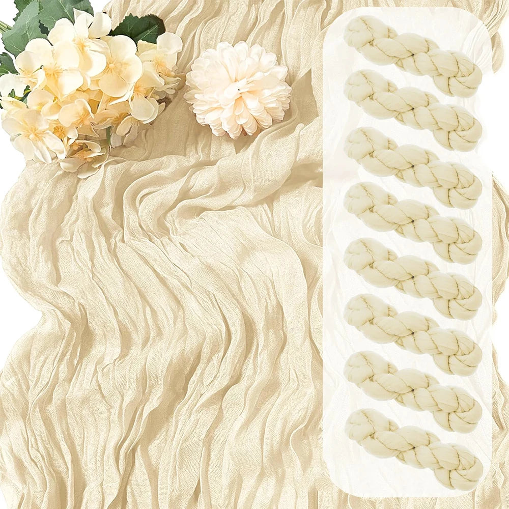 A beige boho gauze table runner with white braided accents and floral greenery.