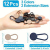 A hand holds a set of 12 metal button extenders in various colors and sizes for use with a waistband.
