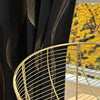 Blackout curtains with gold marble pattern and grommet top next to a gold wire table.