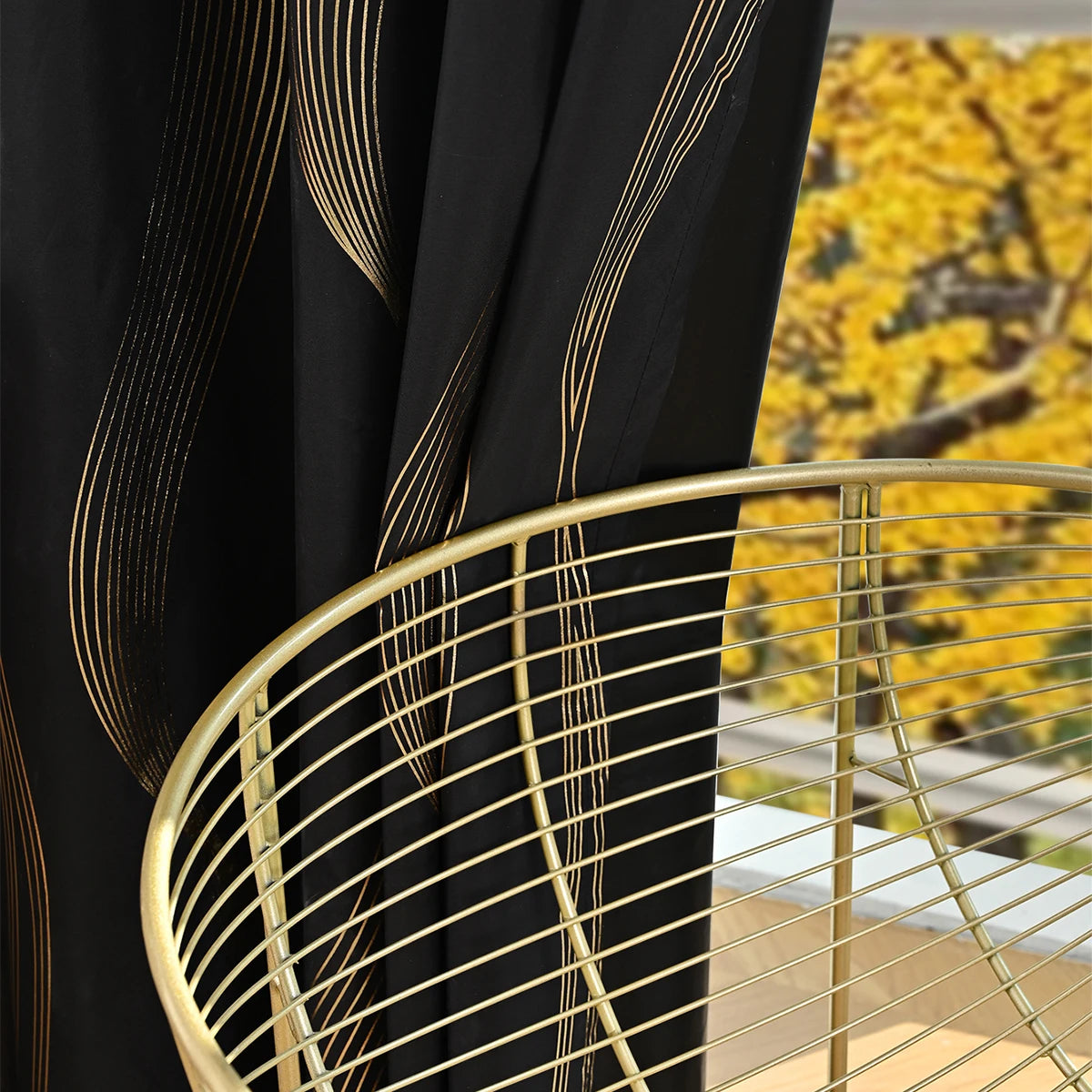 Blackout curtains with gold marble pattern and grommet top next to a gold wire table.
