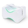 White memory foam knee pillow for side sleepers with adjustable straps, showing a green contoured design.