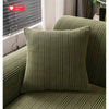 A close-up of a textured olive green fleece cushion and sofa slipcover.