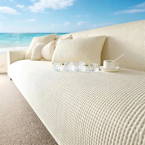 A white anti-slip summer sofa cover with light cushions and ice cubes on a modern outdoor sofa.
