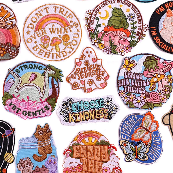 A collection of iron-on embroidery patches featuring inspirational phrases like Don't Trip Over What You, Believe In Yourself