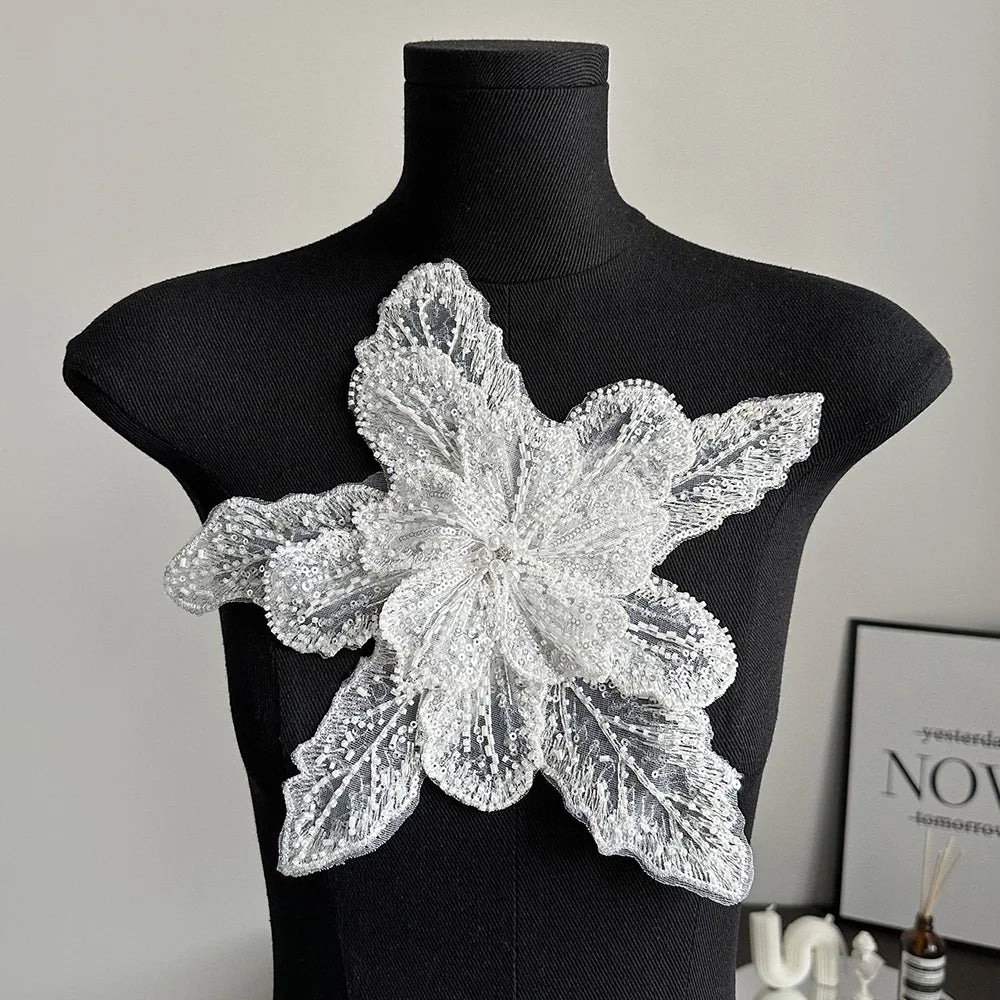 Silver sequin lace applique fabric patches shaped like a multi-petaled flower displayed on a black mannequin.