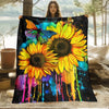 A vibrant floral blanket featuring large yellow sunflowers and colorful paint splatters against a black background.