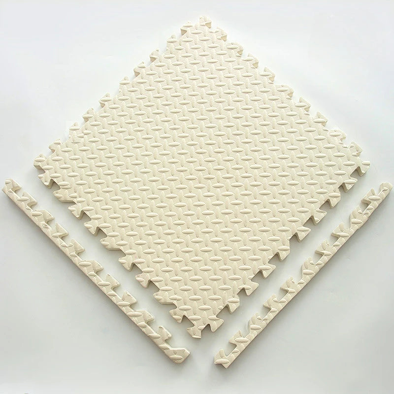A beige soft interlocking foam play mat with a diamond pattern is shown on a white surface.