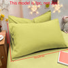 A set of light green matte solid color pillowcases displayed on a bed with decorative star lights.