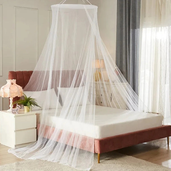 A sheer white mosquito net draped over a bed, providing protection for the bedding and surrounding area.