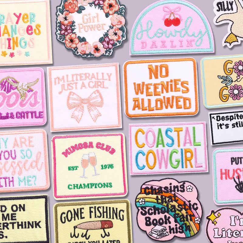 A collection of embroidered letter slogan patches featuring phrases like Girl Power No Weenies Allowed and Coastal Cowgirl