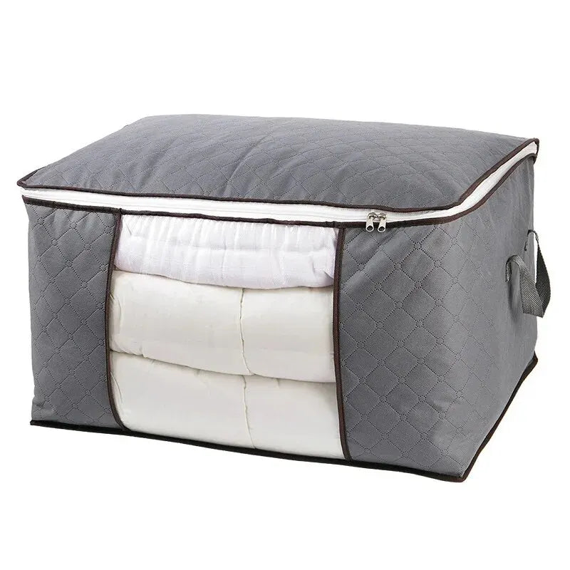 A gray portable quilt and clothing storage bag with a quilted exterior and white lining.
