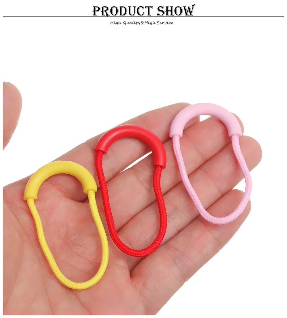 Three U-shape zipper pull straps in red, pink, and yellow are displayed on a hand.