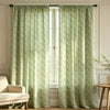Light sage green floral print curtains hanging in a white window frame with natural light filtering through.