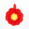 A bright red, fluffy kitchen dish scrubber sponge with a yellow center.