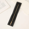 A black PU leather zipper frame with studs is shown on a white surface.