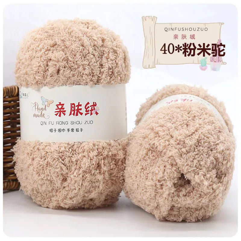 A pair of fluffy, light brown coral velvet yarn balls for crafting.