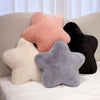 A collection of star-shaped decorative throw pillows in shades of peach, cream, and gray resting on a light-colored sofa.
