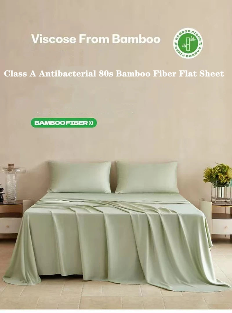 A flat sheet made from bamboo fiber in a light green color is displayed on a bed.