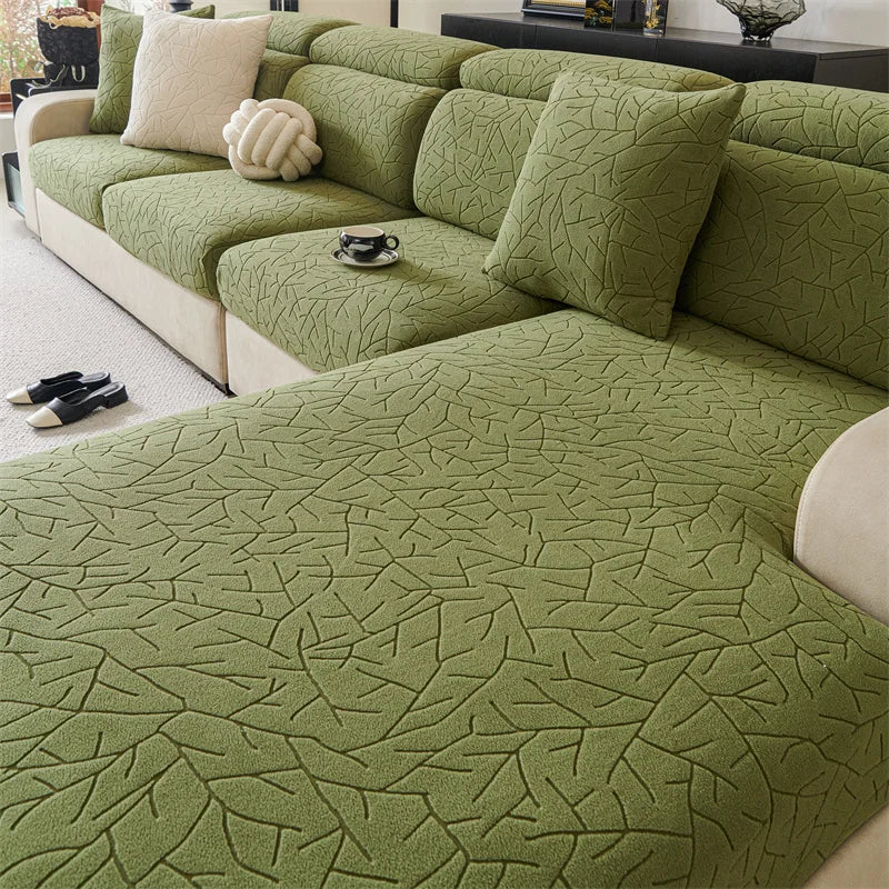 A moss green patterned jacquard sofa cover featuring a branch design on a modern sectional sofa.