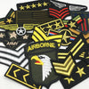 A collection of embroidered tactical clothing patches featuring military insignia and emblems.