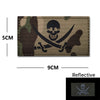 A dark green and brown camouflage embroidery patch featuring a black skull and crossed swords design.