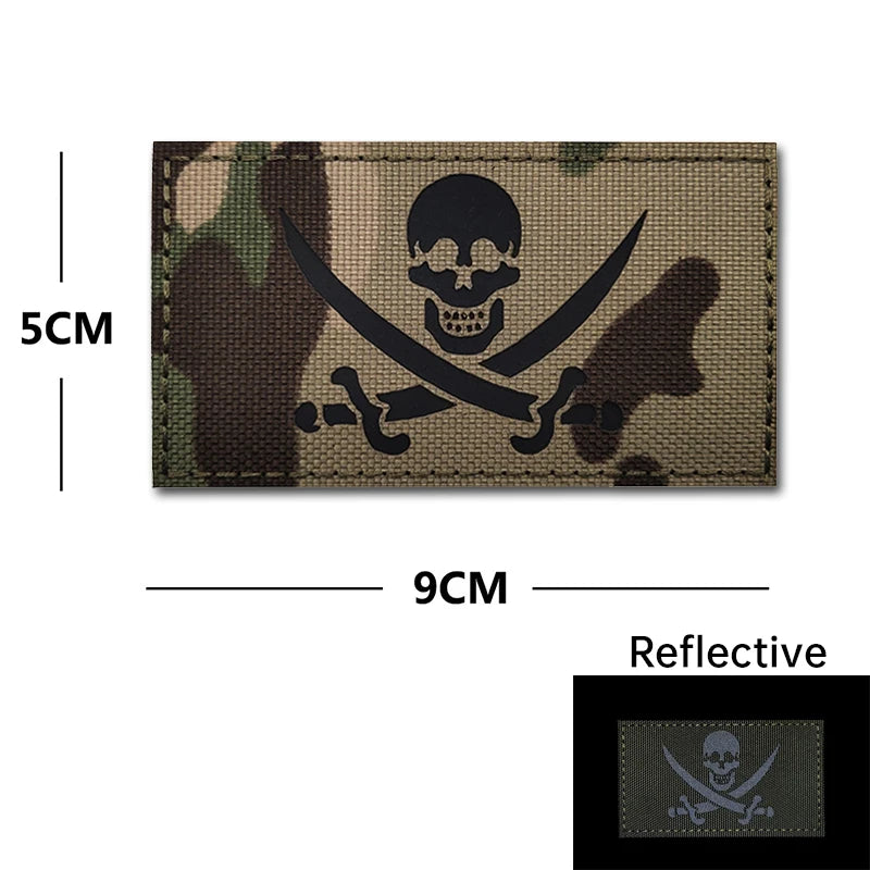 A dark green and brown camouflage embroidery patch featuring a black skull and crossed swords design.