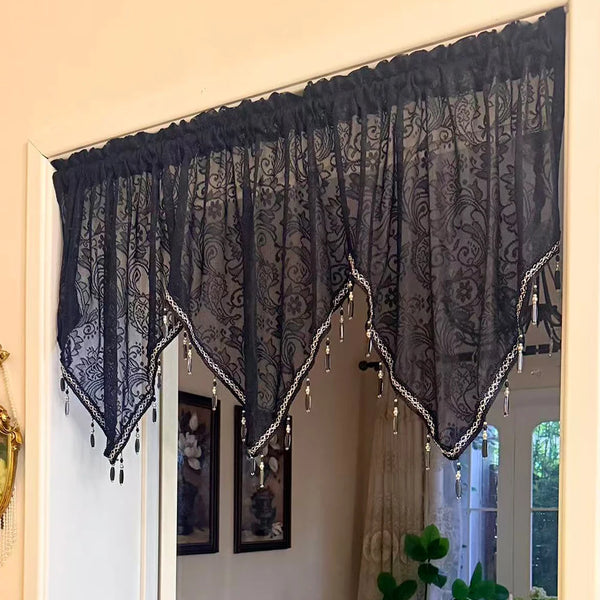Elegant black lace curtain valance hanging over a window with silver fringe details.