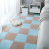 A light blue and beige checkered play mat with soft plush tiles for children in a bright room.