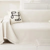 A white waterproof chenille sofa cover with a black embroidered design on a light-colored sofa.