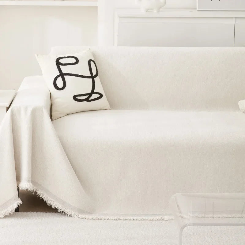 A white waterproof chenille sofa cover with a black embroidered design on a light-colored sofa.