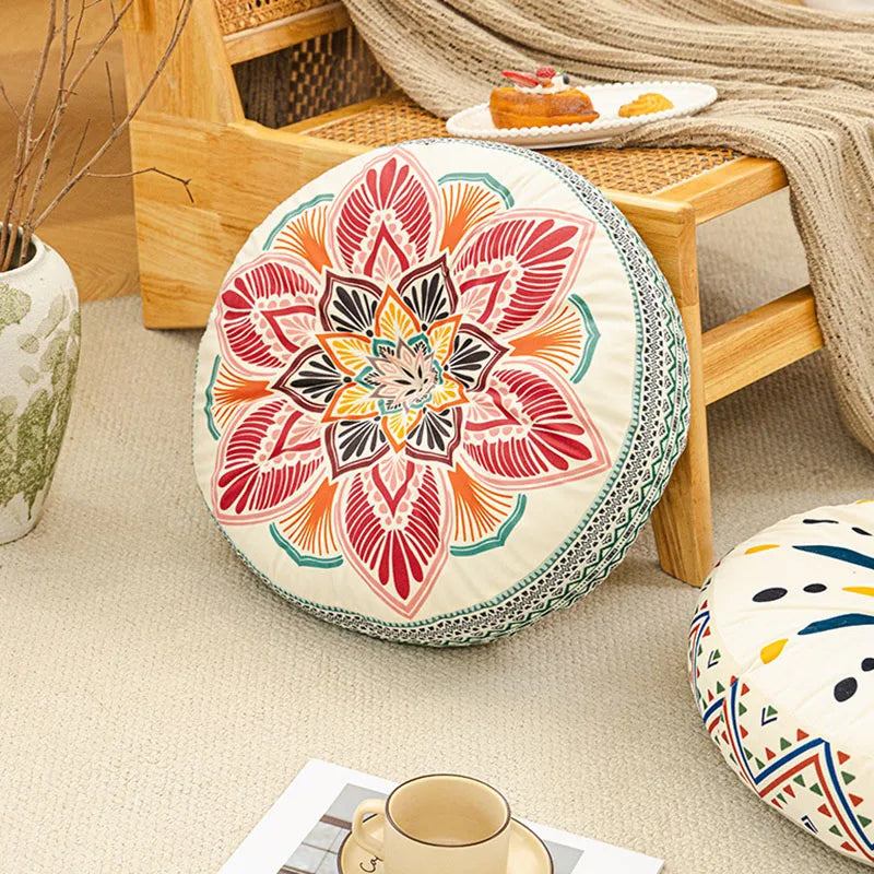 A round bohemian tatami cushion with intricate floral patterns rests on a wooden floor frame.